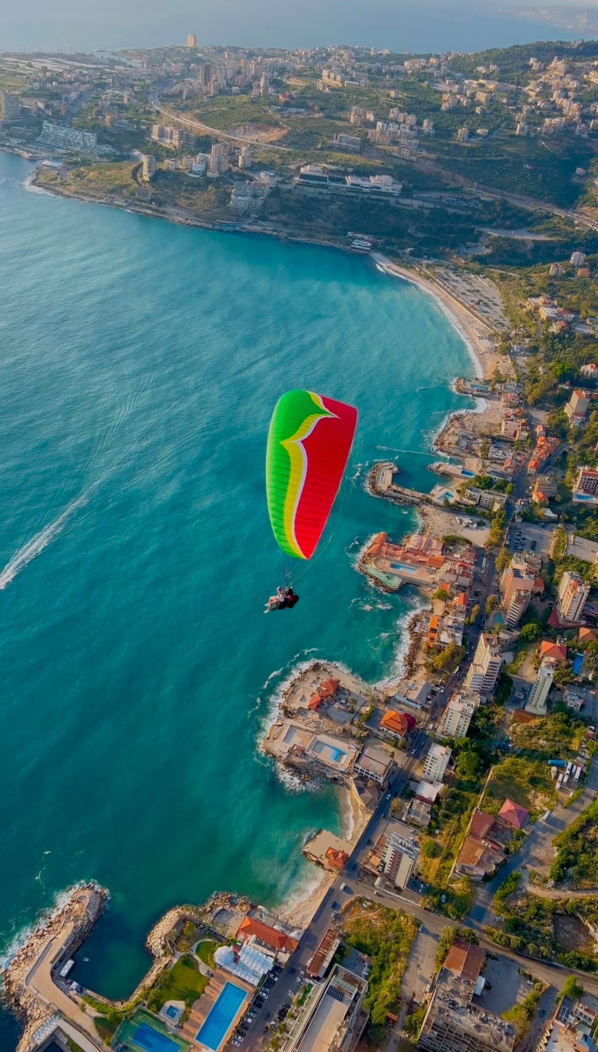 Tandem paraglider soaring over turquoise Jounieh Bay coastline, Lebanon — LebPar tours