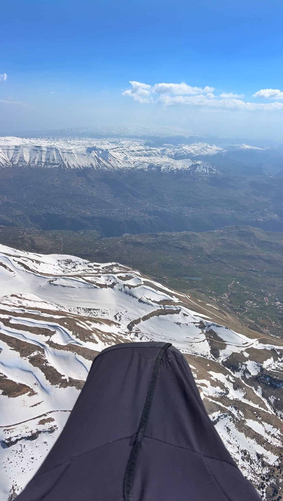 Paragliding view over snow-covered Ehden mountains and valley villages