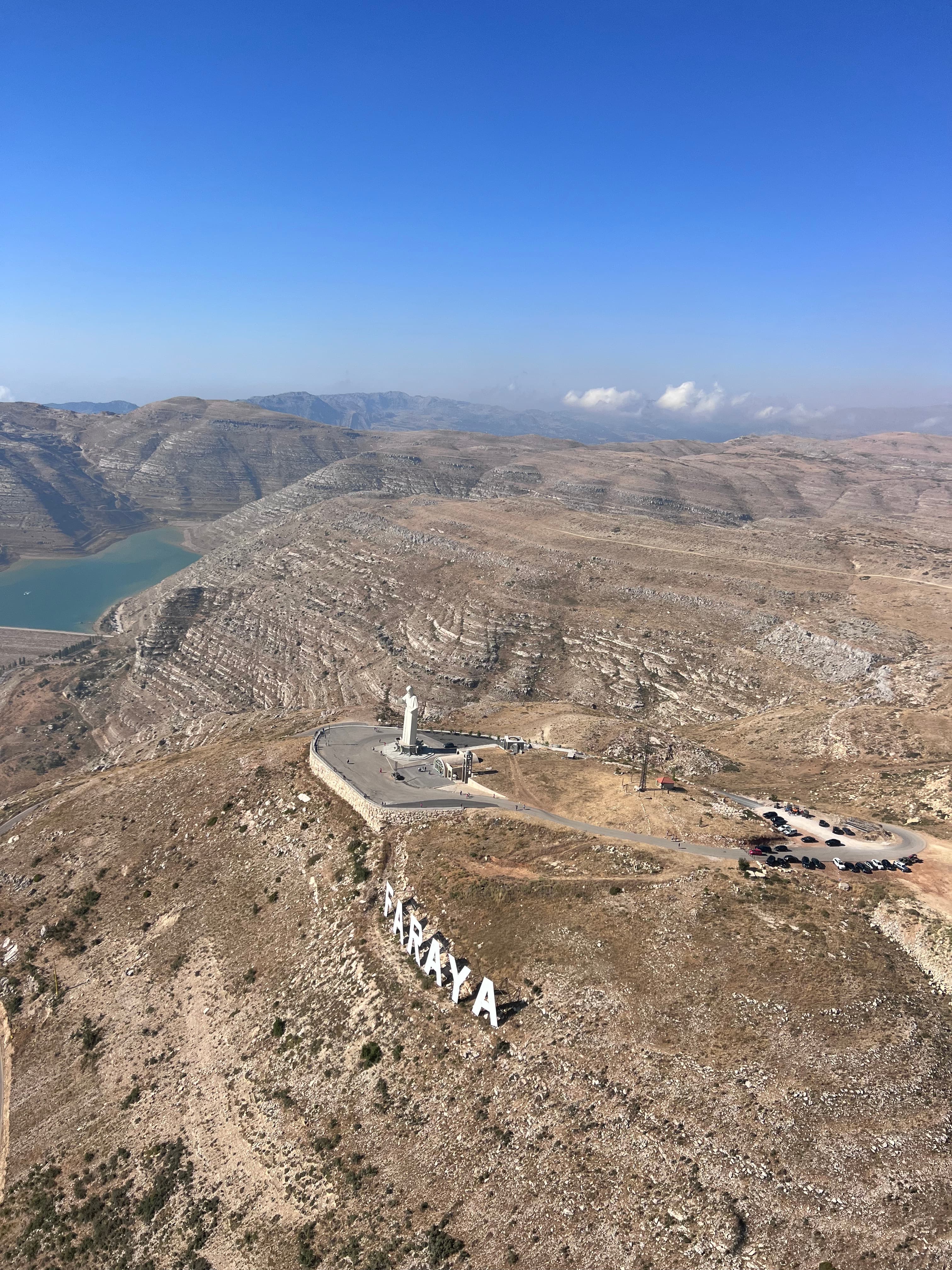 Saint Charbel statue and FARAYA sign above Shabrouh reservoir, Lebanon